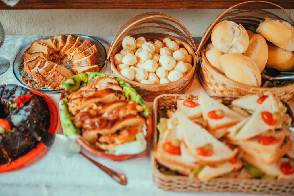 A variety of baked goods and sandwiches beautifully arranged for a food photoshoot.